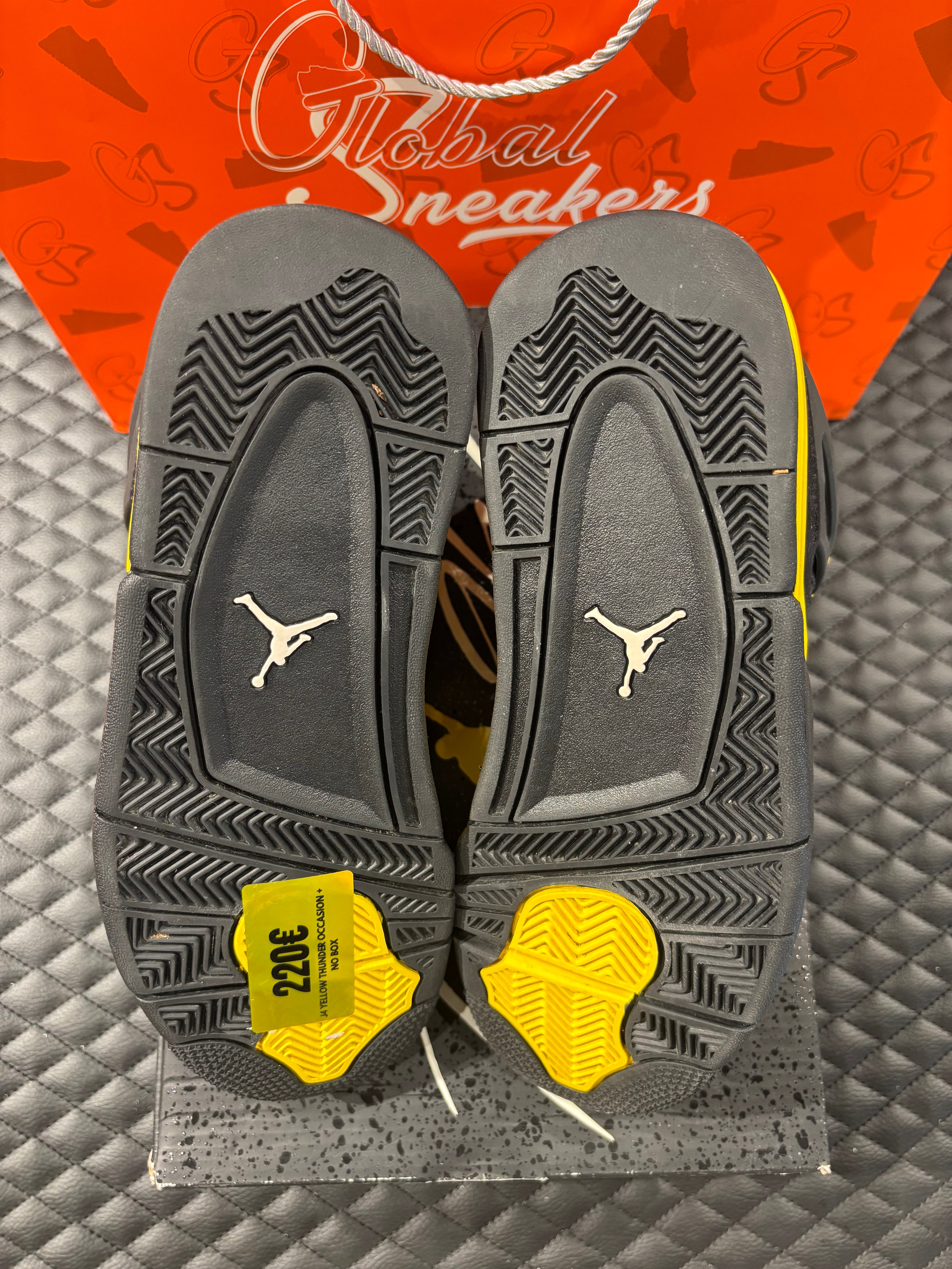 Jordan 4 Rétro Thunder d’occasion en état 8,5/10, suede noir, détails jaunes, sneaker sans boîte.
