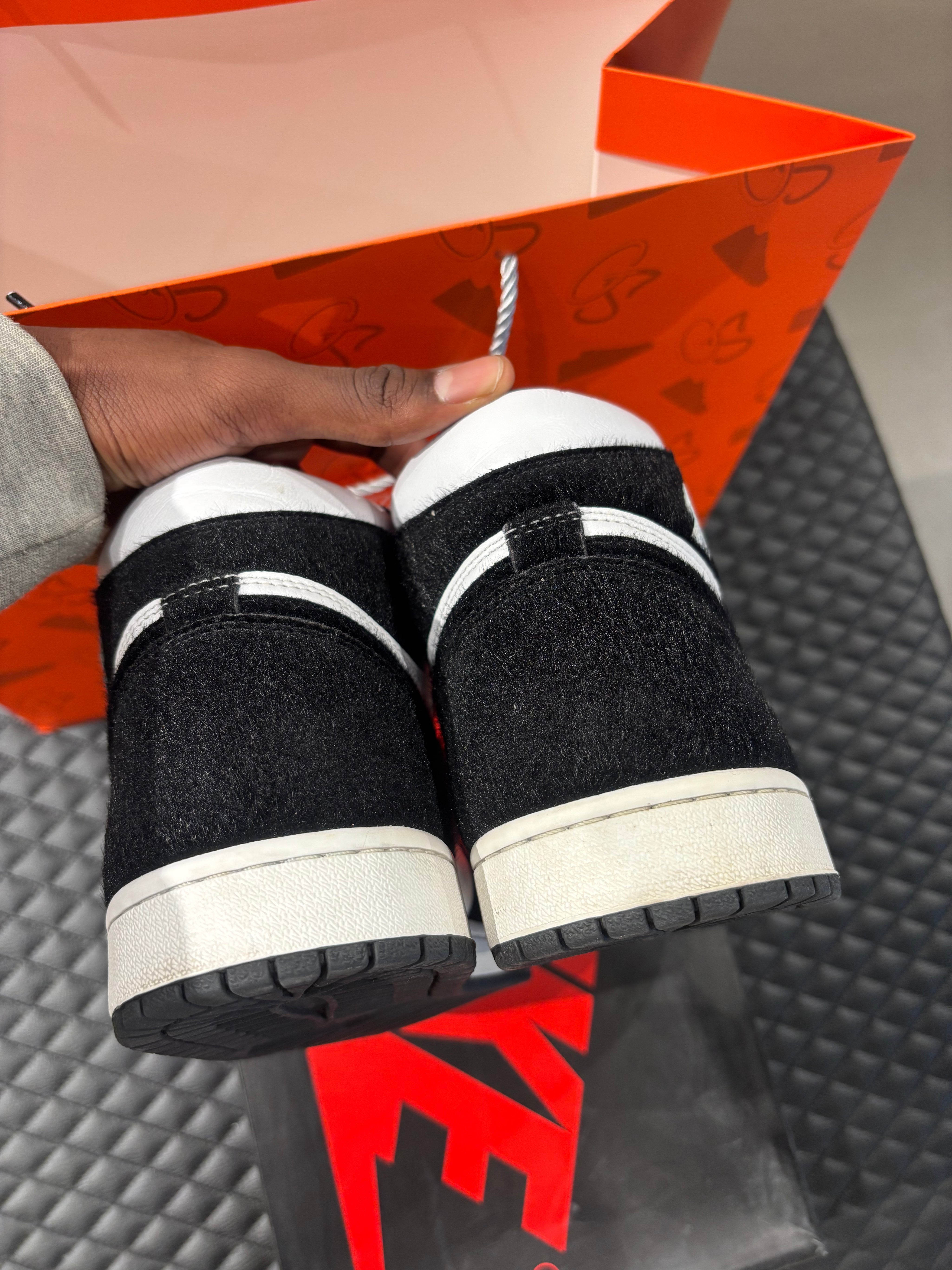 Jordan 1 Retro High Twist d’occasion en état 9/10, cuir blanc et poils noirs, silhouette haute iconique, sneaker avec boîte.