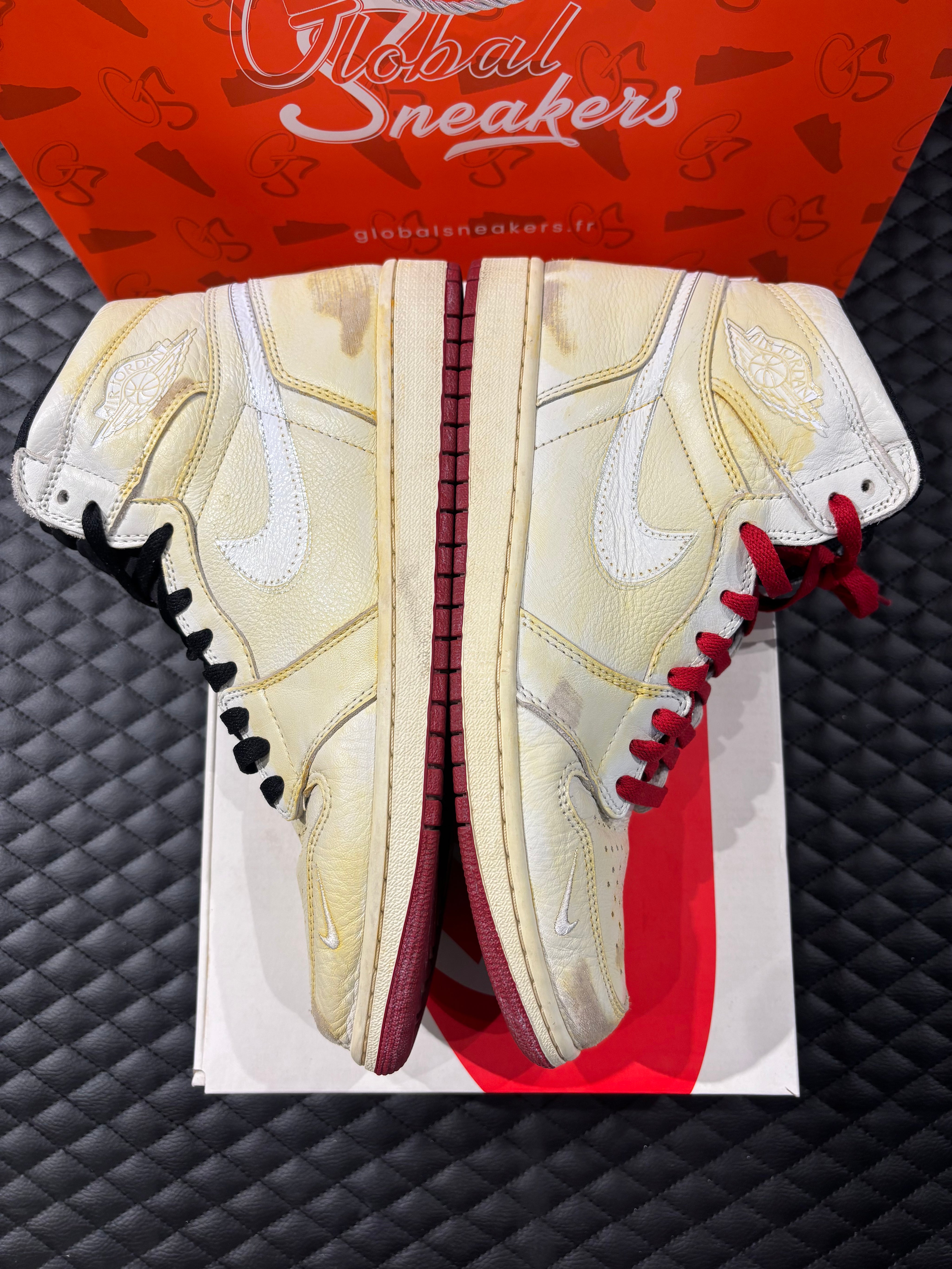 Jordan 1 High Rétro Nigel Sylvester d’occasion en état 8,5/10, cuir blanc patiné, détails crème et noirs, sneaker avec boîte.