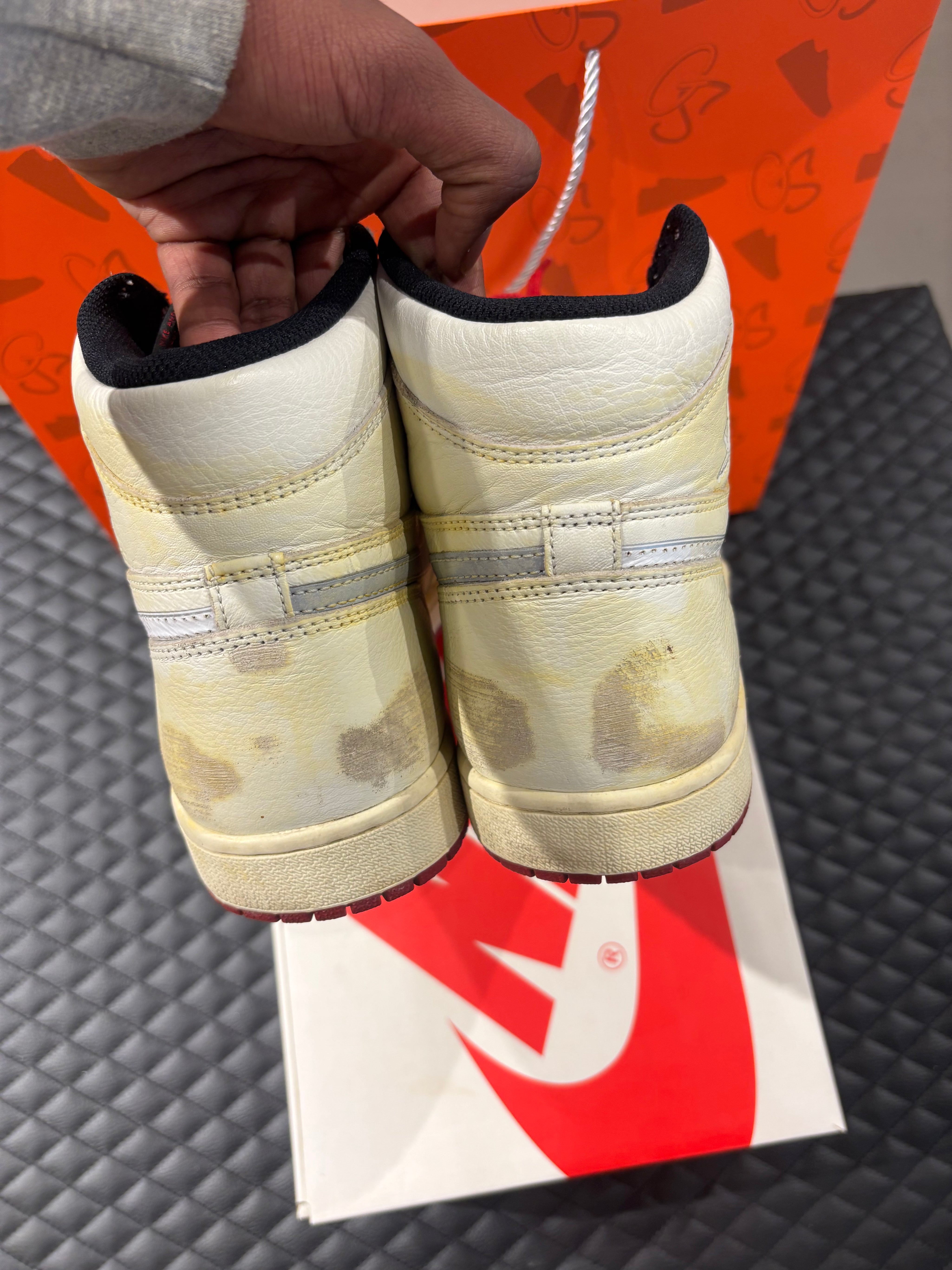 Jordan 1 High Rétro Nigel Sylvester d’occasion en état 8,5/10, cuir blanc patiné, détails crème et noirs, sneaker avec boîte.