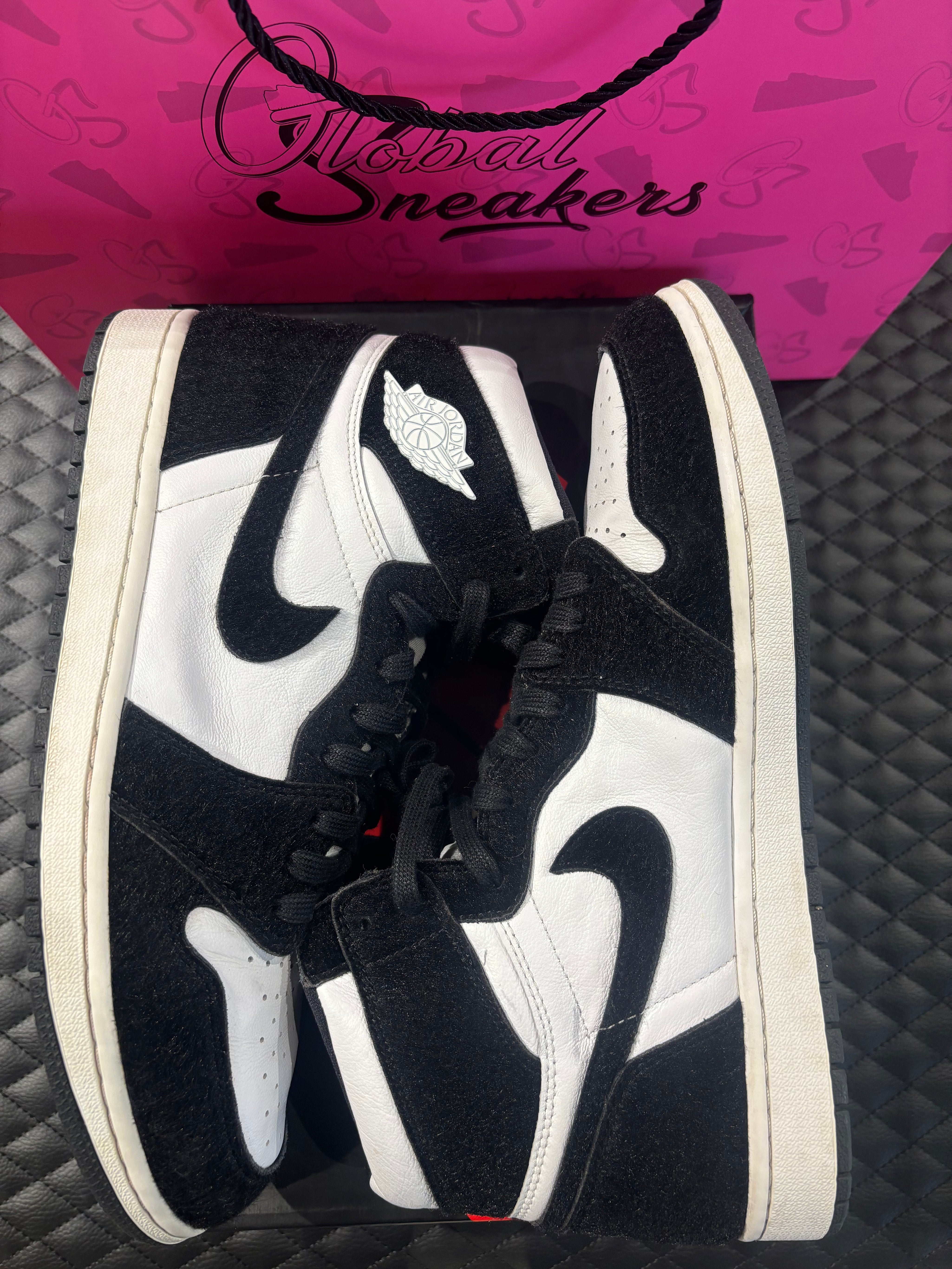 Jordan 1 Retro High Twist d’occasion en état 9,9/10, cuir blanc et poils noirs, silhouette haute iconique, sneaker avec boîte.

