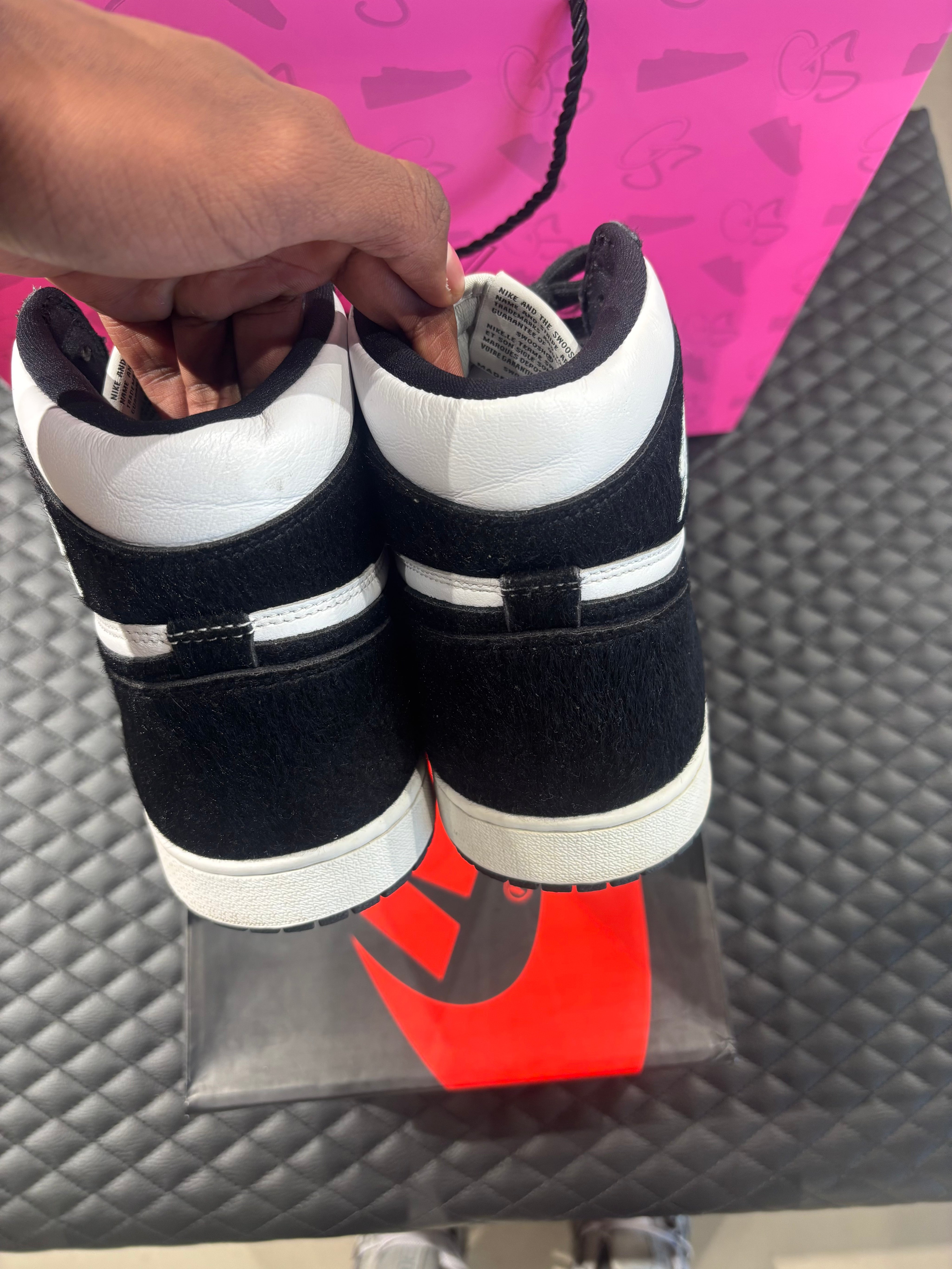 Jordan 1 Retro High Twist d’occasion en état 9,9/10, cuir blanc et poils noirs, silhouette haute iconique, sneaker avec boîte.

