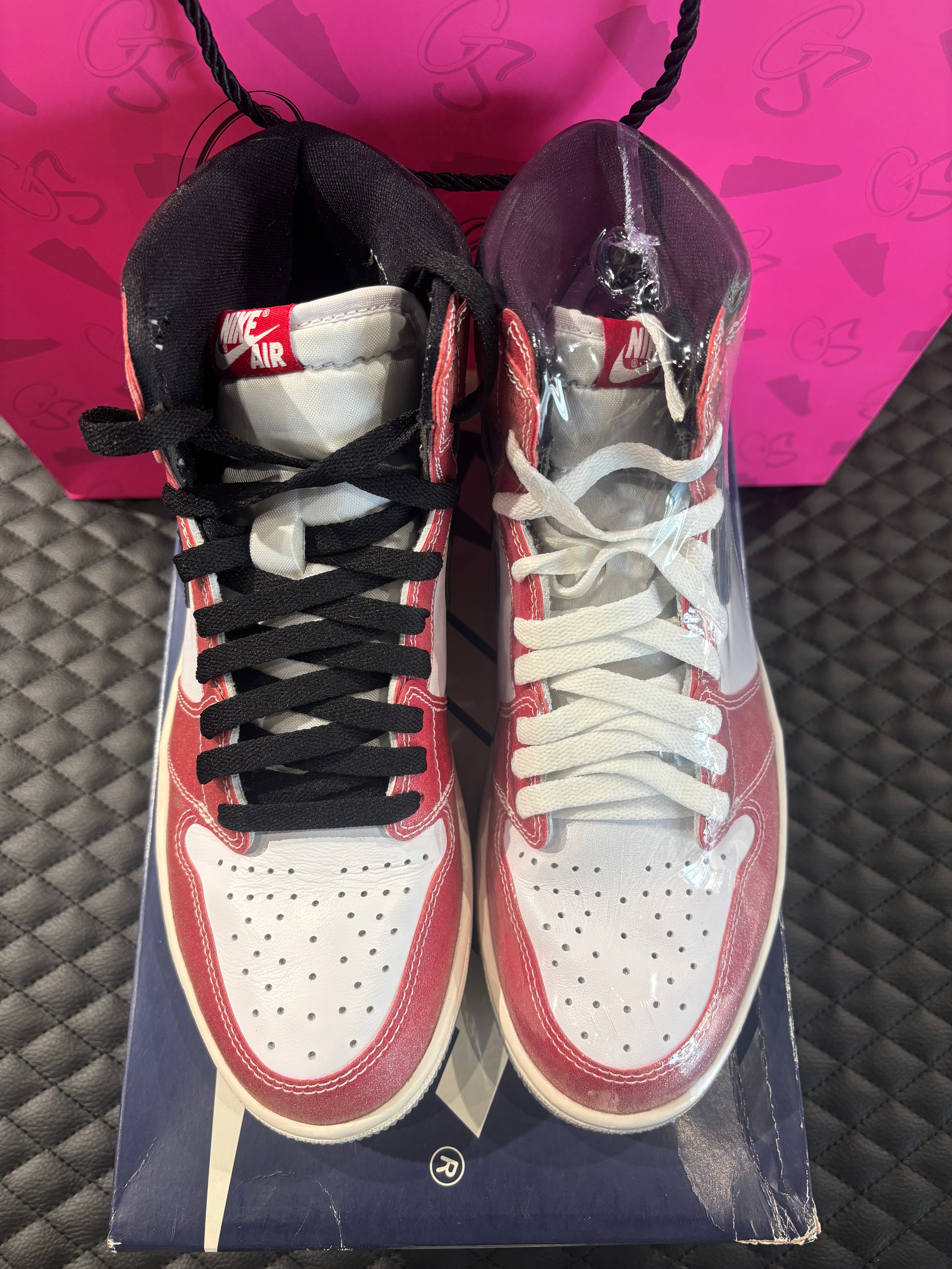 Jordan 1 High Rétro Trophy Room Chicago d’occasion en état 9,9/10, cuir rouge givré, panneaux blancs, détails noirs et lacets bleus, sneaker avec boîte.
