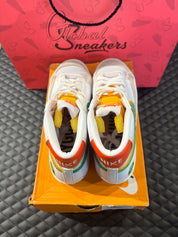 Nike Blazer Mid 77 Raygun d’occasion en état 9/10, cuir blanc, accents orange et jaune, silhouette montante classique, sneaker avec boîte.