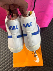 Nike Blazer Mid 77 Blanc Racer Blue d’occasion en état 9,9/10, cuir blanc premium, Swoosh bleu vif, silhouette montante classique, sneaker avec boîte.

