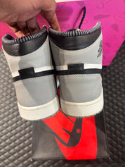 Jordan 1 Retro Barons d’occasion en état 9,9/10, cuir gris, blanc et noir, silhouette haute classique, sneaker avec boîte.

