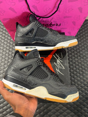 Jordan 4 Rétro Laser noir et gomme d’occasion en état 9/10, cuir noir gravé au laser, semelle gomme, sneaker avec boîte.