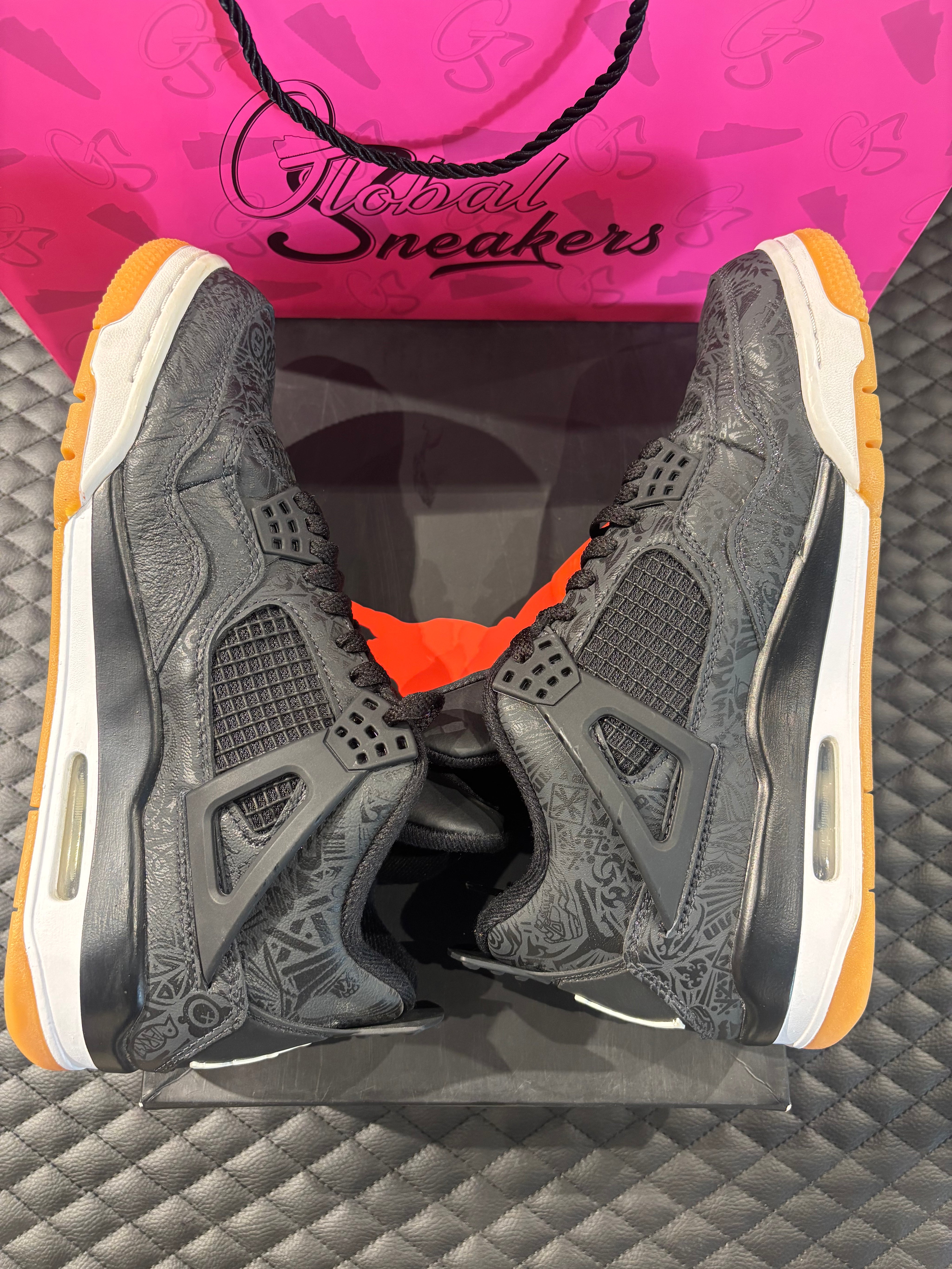 Jordan 4 Rétro Laser noir et gomme d’occasion en état 9/10, cuir noir gravé au laser, semelle gomme, sneaker avec boîte.