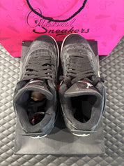 Jordan 4 Rétro Laser noir et gomme d’occasion en état 9/10, cuir noir gravé au laser, semelle gomme, sneaker avec boîte.