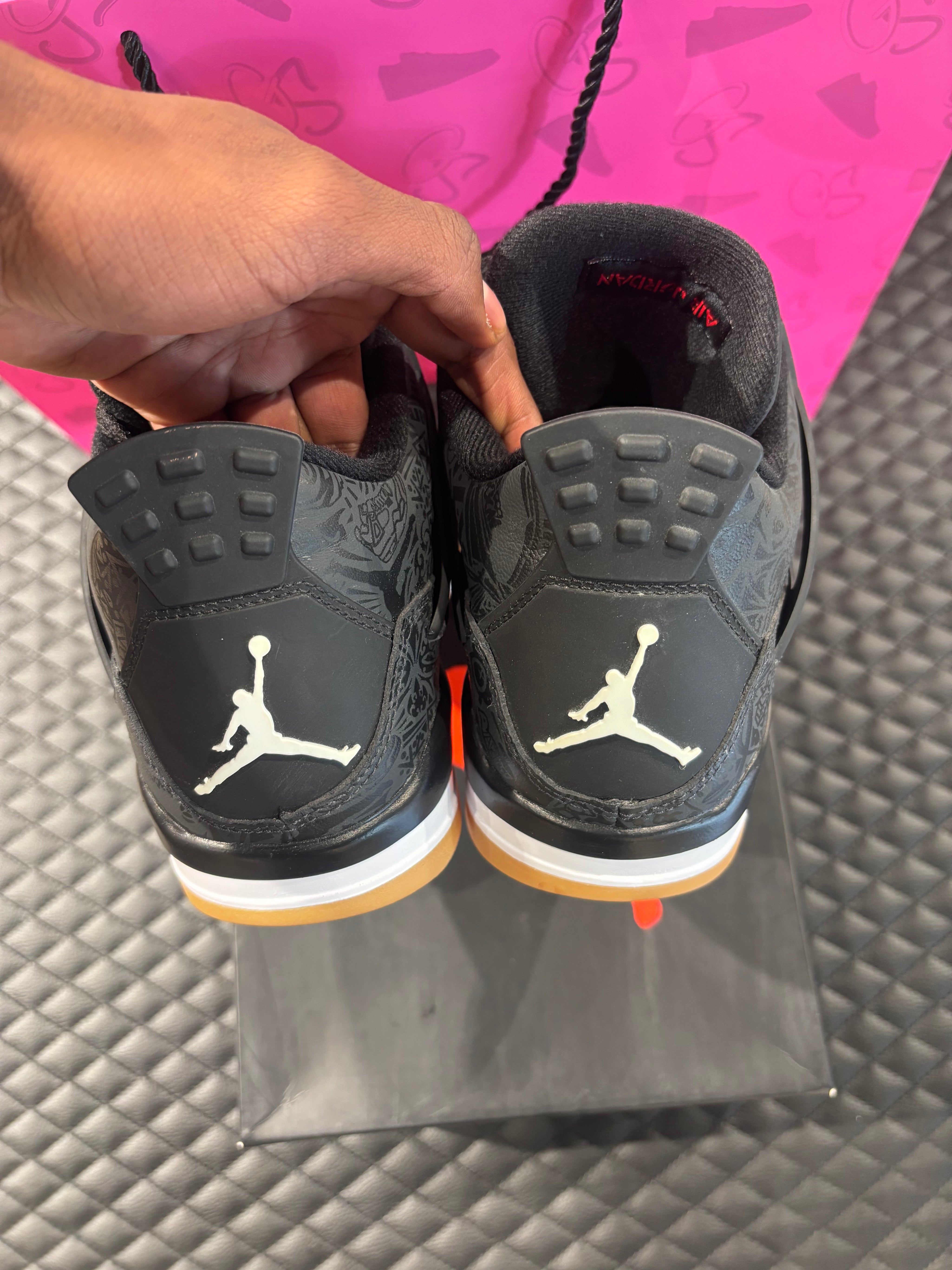 Jordan 4 Rétro Laser noir et gomme d’occasion en état 9/10, cuir noir gravé au laser, semelle gomme, sneaker avec boîte.