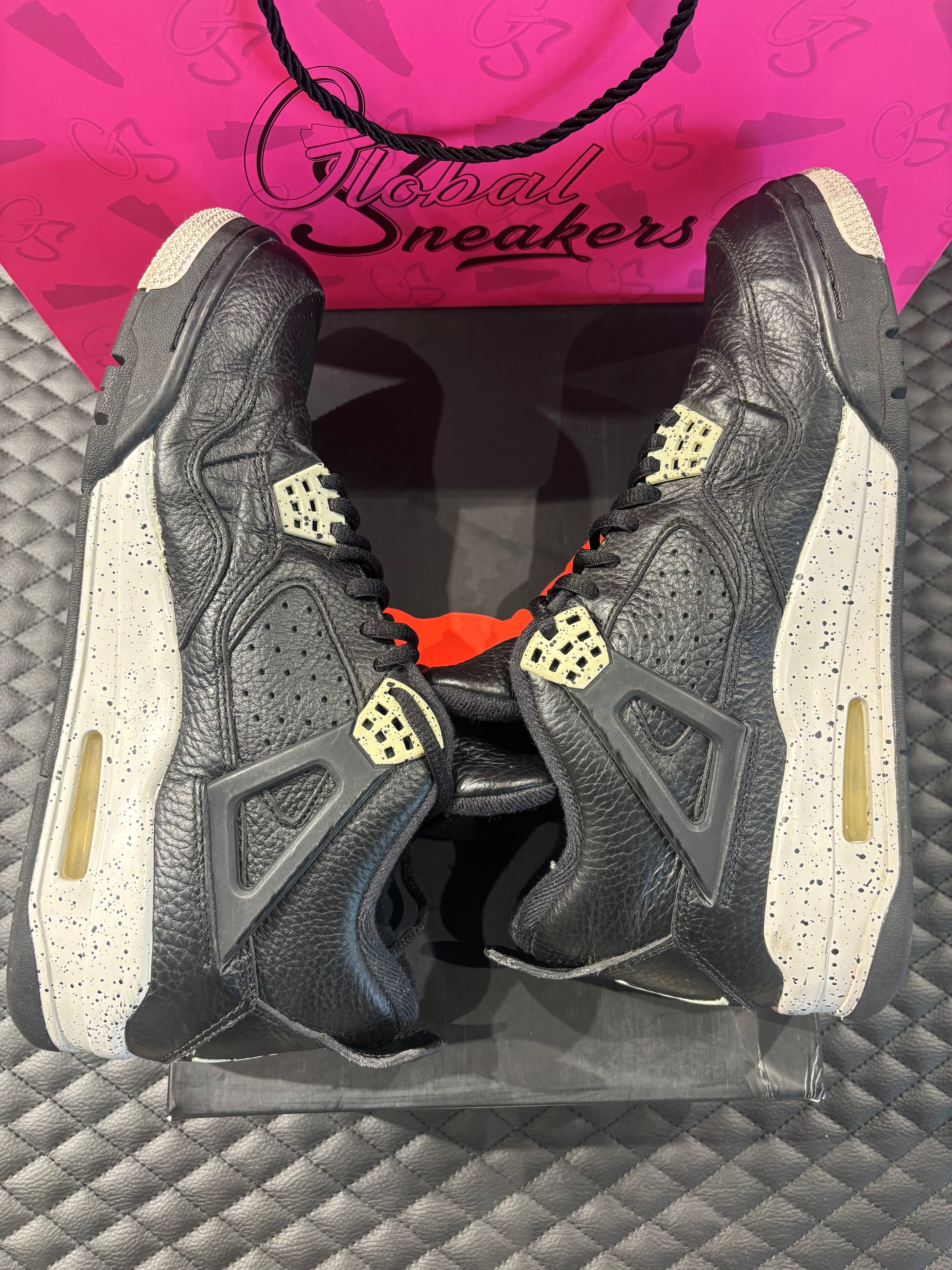 Jordan 4 Rétro Oreo d’occasion en état 8,5/10, cuir noir, détails gris mouchetés, silhouette emblématique, sneaker avec boîte.

