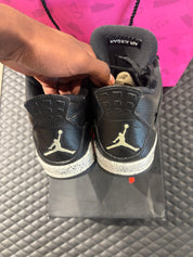 Jordan 4 Rétro Oreo d’occasion en état 8,5/10, cuir noir, détails gris mouchetés, silhouette emblématique, sneaker avec boîte.

