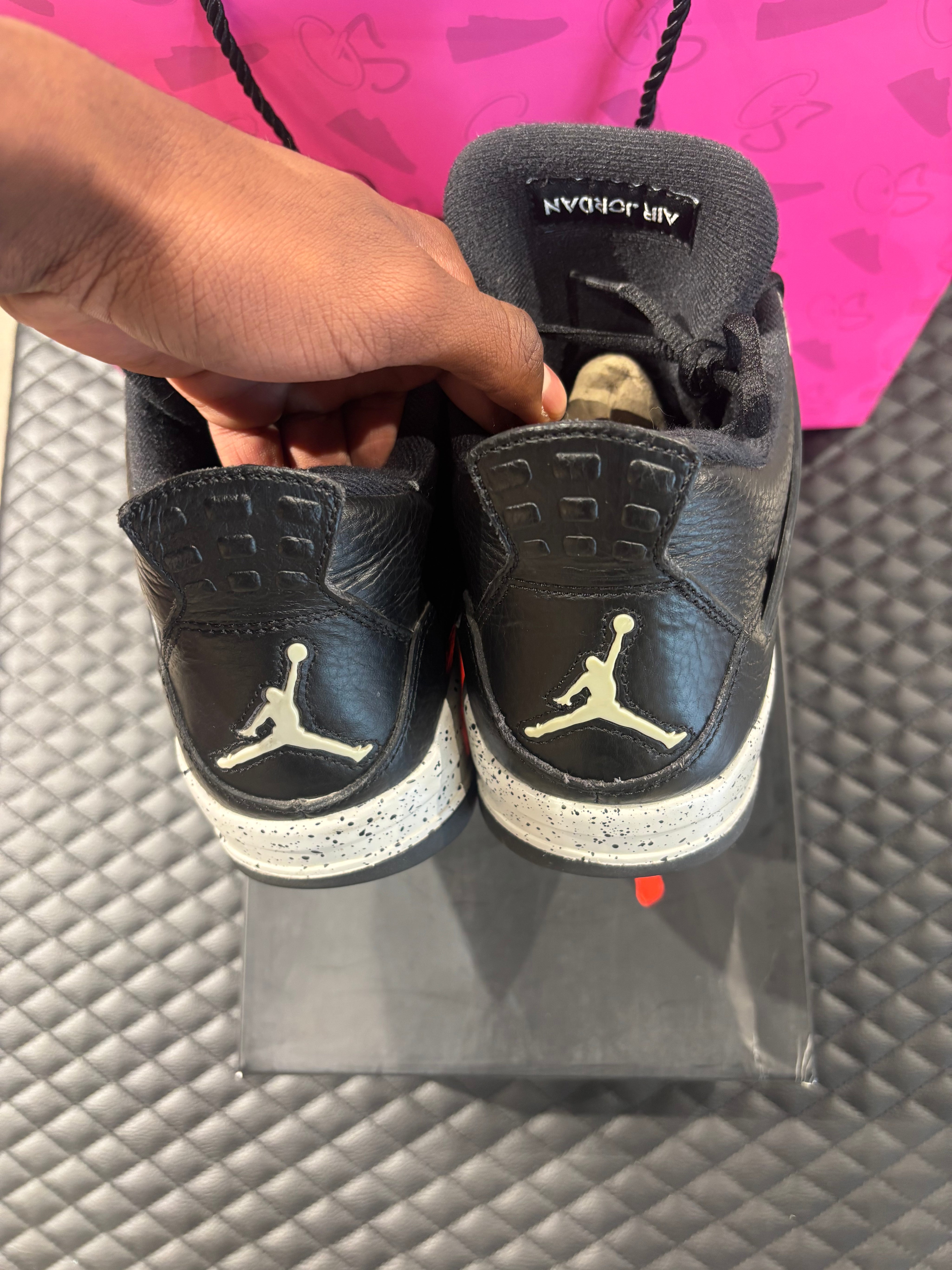 Jordan 4 Rétro Oreo d’occasion en état 8,5/10, cuir noir, détails gris mouchetés, silhouette emblématique, sneaker avec boîte.

