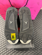 Jordan 4 Rétro Oreo d’occasion en état 8,5/10, cuir noir, détails gris mouchetés, silhouette emblématique, sneaker avec boîte.

