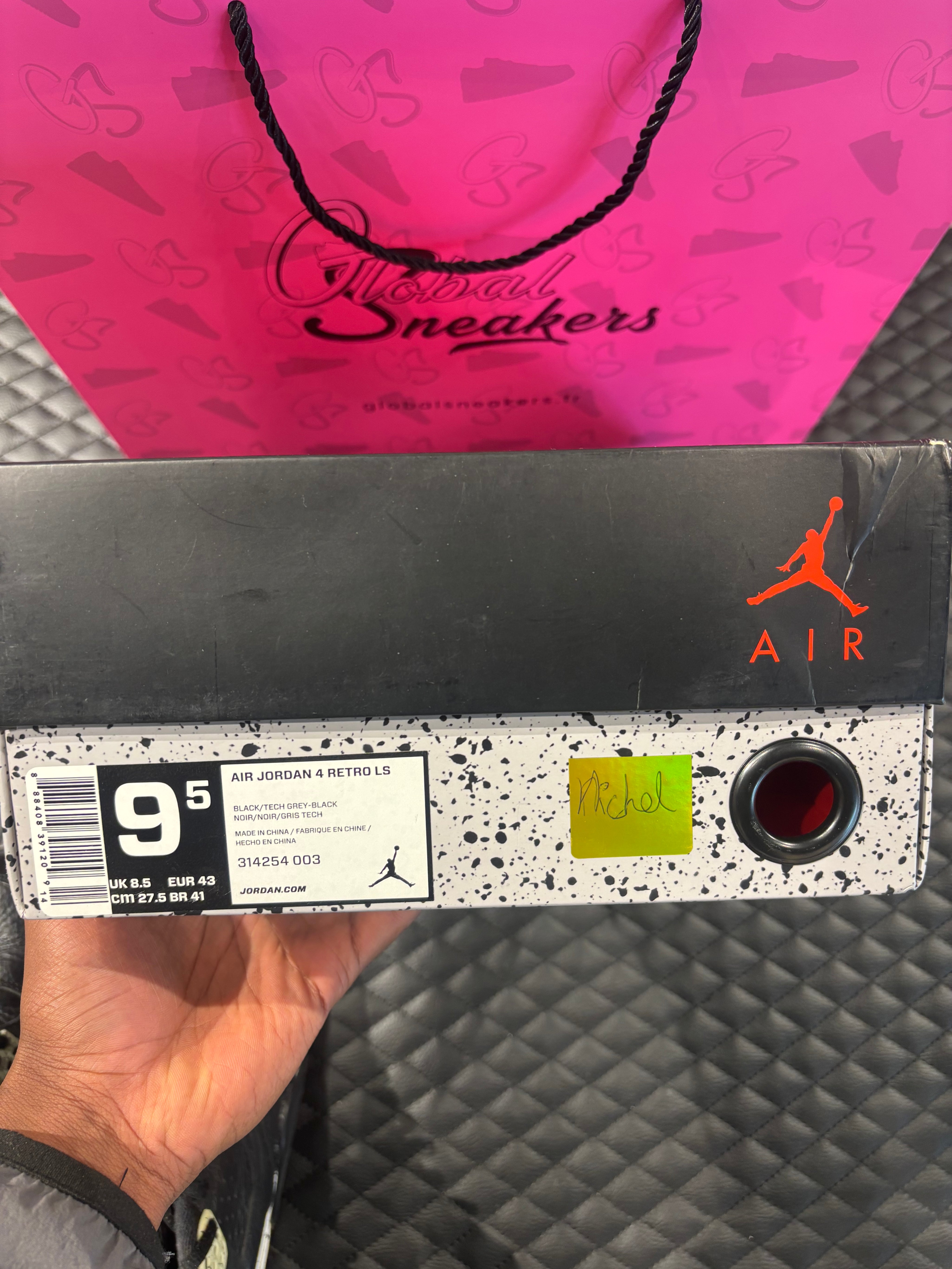 Jordan 4 Rétro Oreo d’occasion en état 8,5/10, cuir noir, détails gris mouchetés, silhouette emblématique, sneaker avec boîte.

