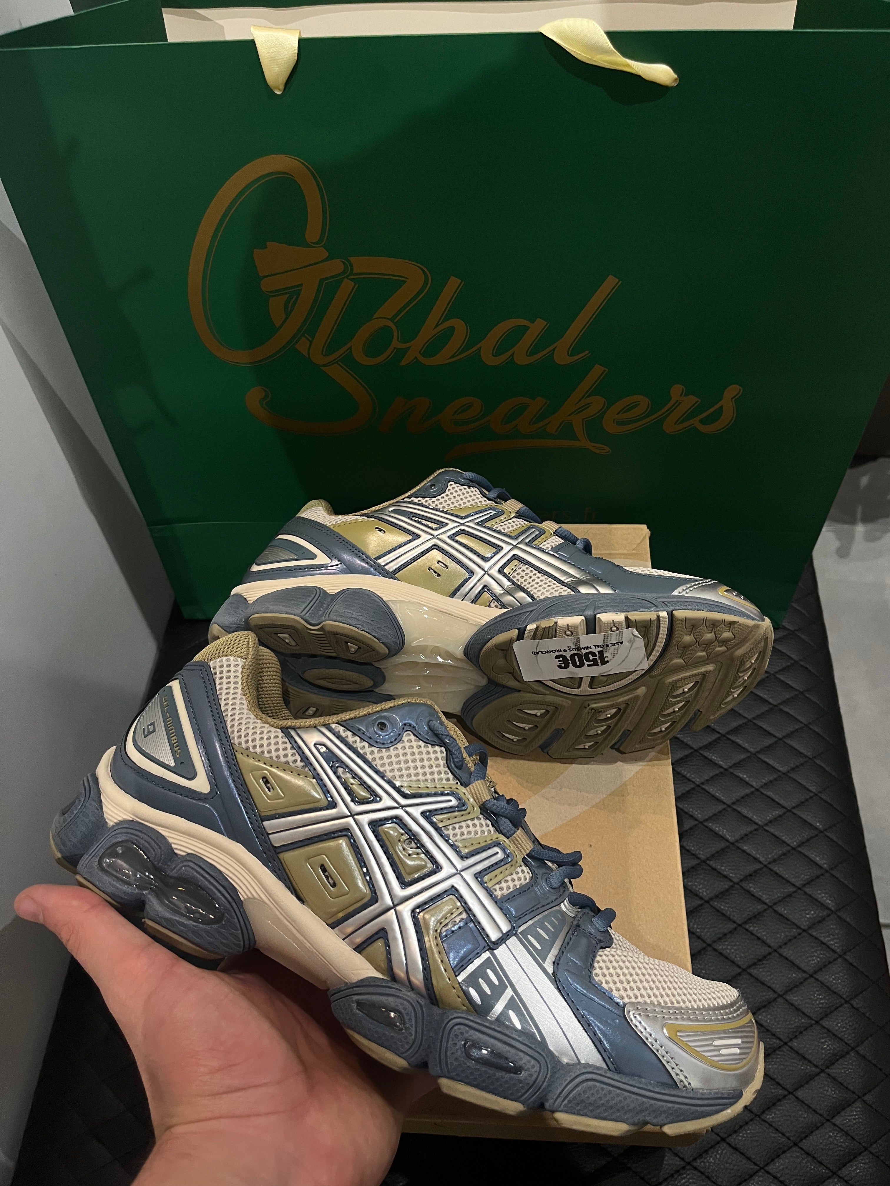 ASICS Gel-Nimbus 9 d’occasion en état 8,5/10, mesh beige et empiècements gris Ironclad, technologie GEL, sneaker avec boîte.
