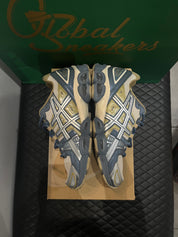 ASICS Gel-Nimbus 9 d’occasion en état 8,5/10, mesh beige et empiècements gris Ironclad, technologie GEL, sneaker avec boîte.
