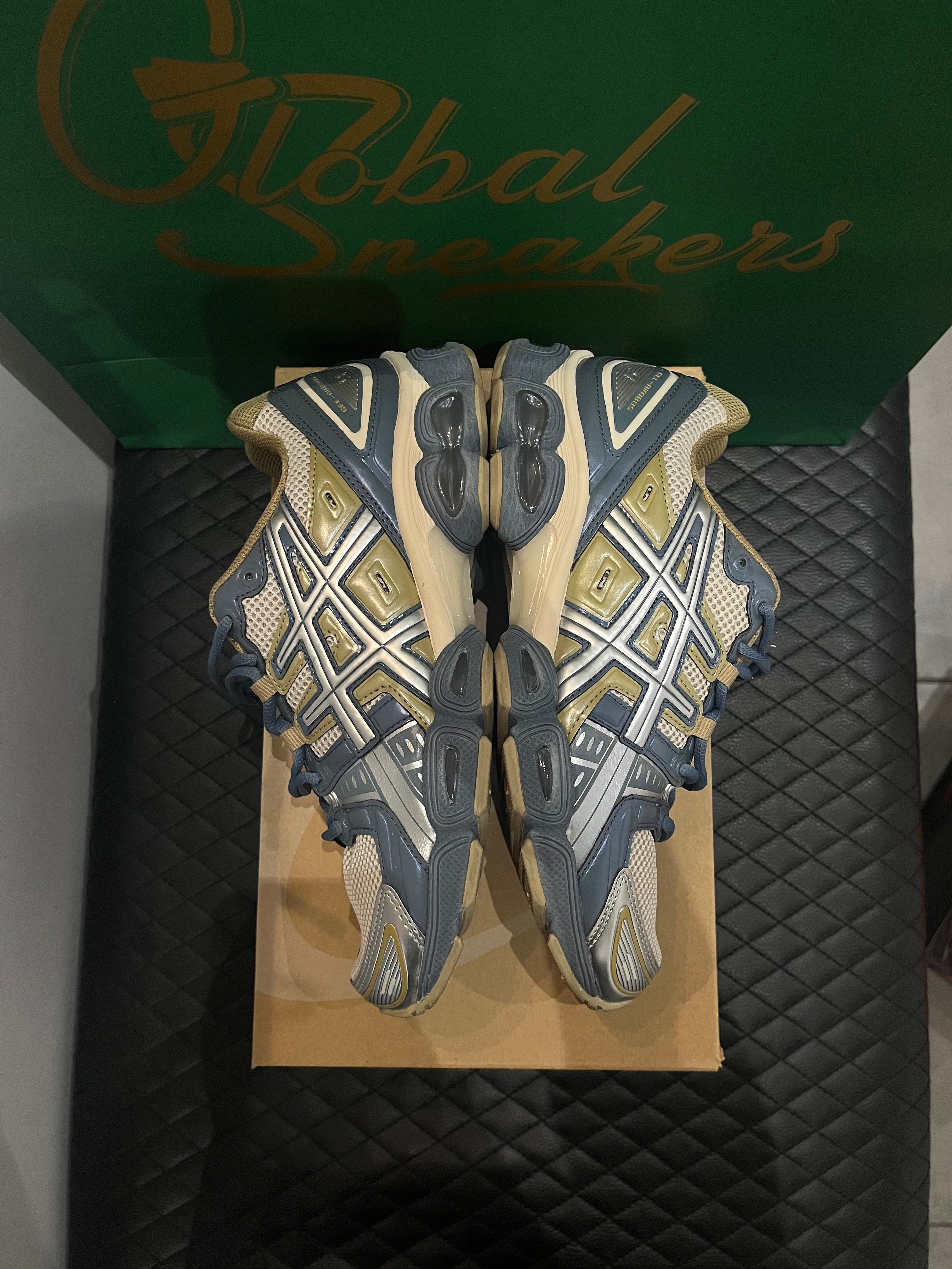 ASICS Gel-Nimbus 9 d’occasion en état 8,5/10, mesh beige et empiècements gris Ironclad, technologie GEL, sneaker avec boîte.
