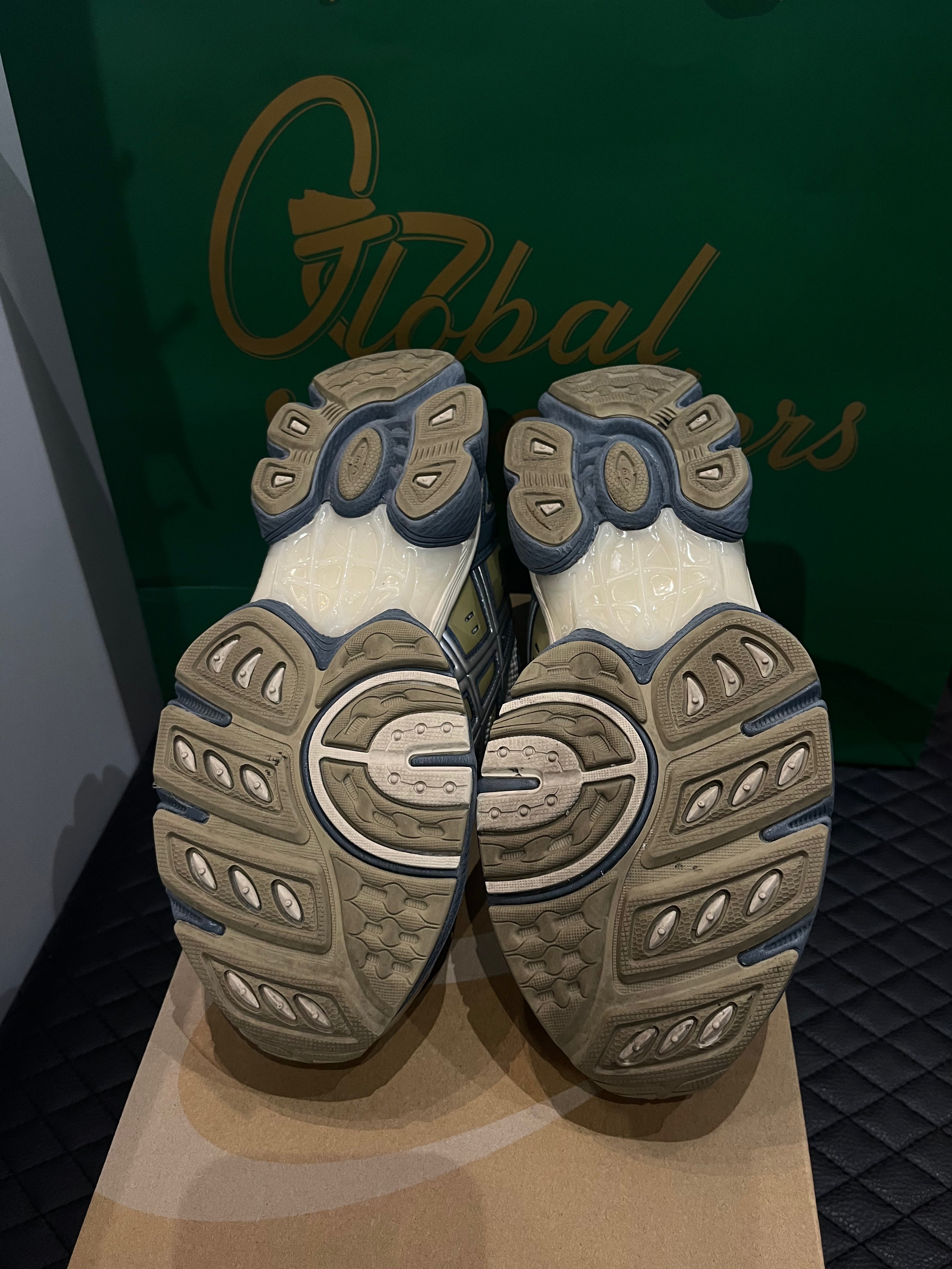 ASICS Gel-Nimbus 9 d’occasion en état 8,5/10, mesh beige et empiècements gris Ironclad, technologie GEL, sneaker avec boîte.
