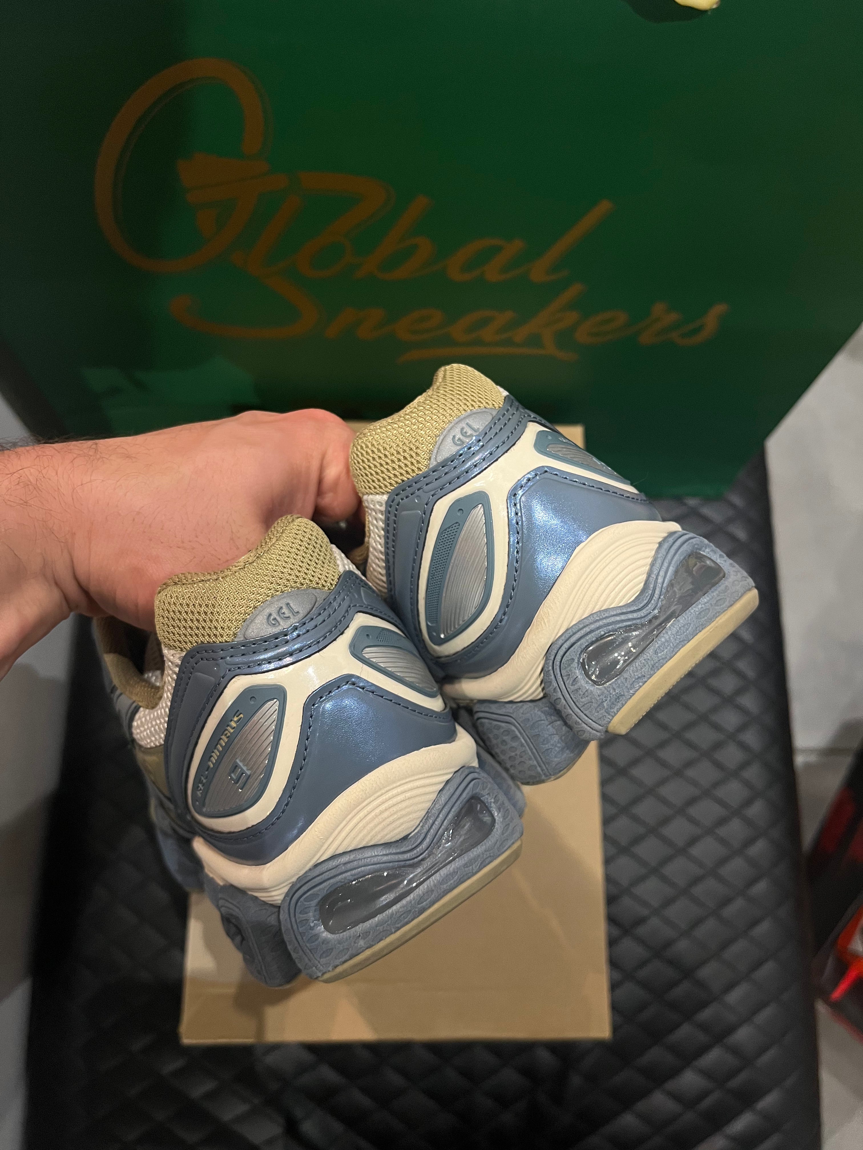 ASICS Gel-Nimbus 9 d’occasion en état 8,5/10, mesh beige et empiècements gris Ironclad, technologie GEL, sneaker avec boîte.
