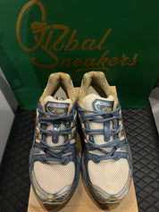 ASICS Gel-Nimbus 9 d’occasion en état 8,5/10, mesh beige et empiècements gris Ironclad, technologie GEL, sneaker avec boîte.
