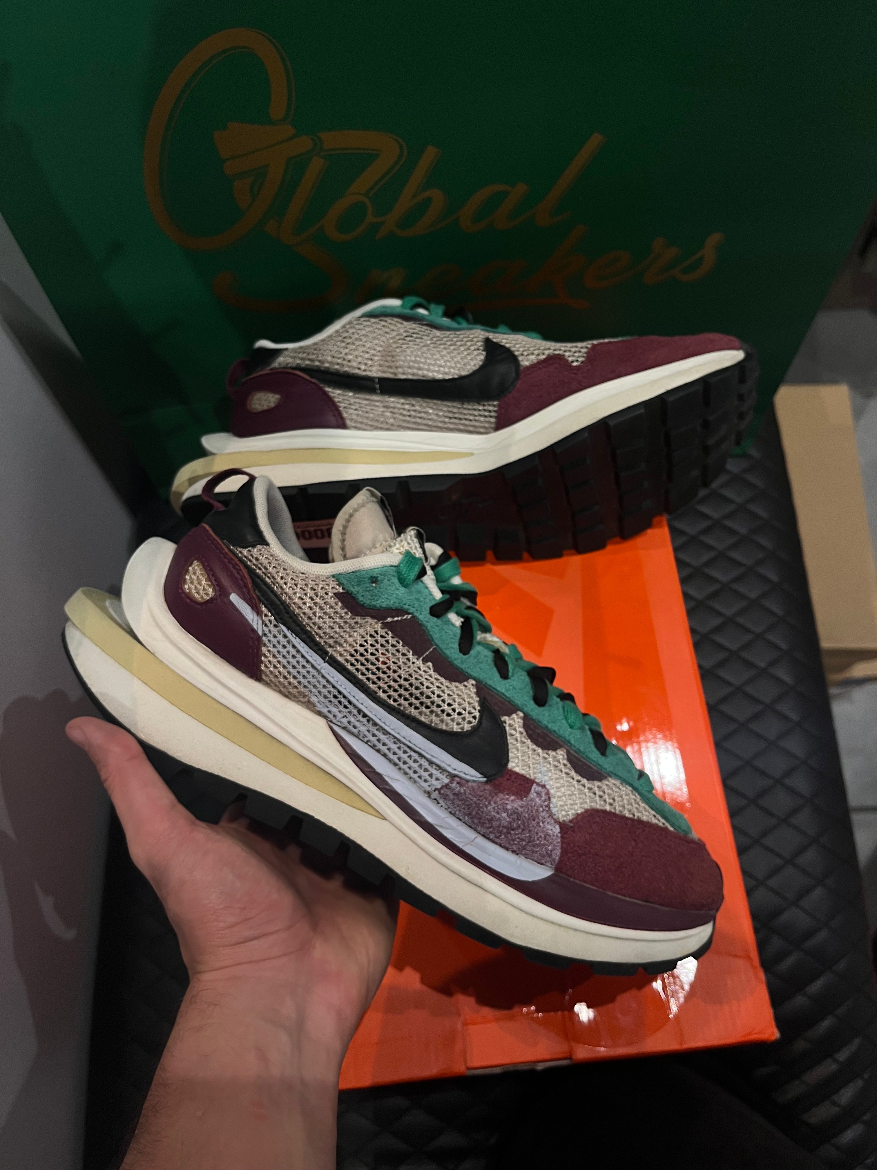 Nike Vaporwaffle Sacai Villain Red Neptune Green d’occasion en état 8,5/10, mesh, suede et cuir, coloris rouge et vert, sneaker avec boîte.
