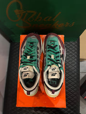 Nike Vaporwaffle Sacai Villain Red Neptune Green d’occasion en état 8,5/10, mesh, suede et cuir, coloris rouge et vert, sneaker avec boîte.
