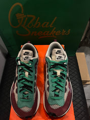 Nike Vaporwaffle Sacai Villain Red Neptune Green d’occasion en état 8,5/10, mesh, suede et cuir, coloris rouge et vert, sneaker avec boîte.
