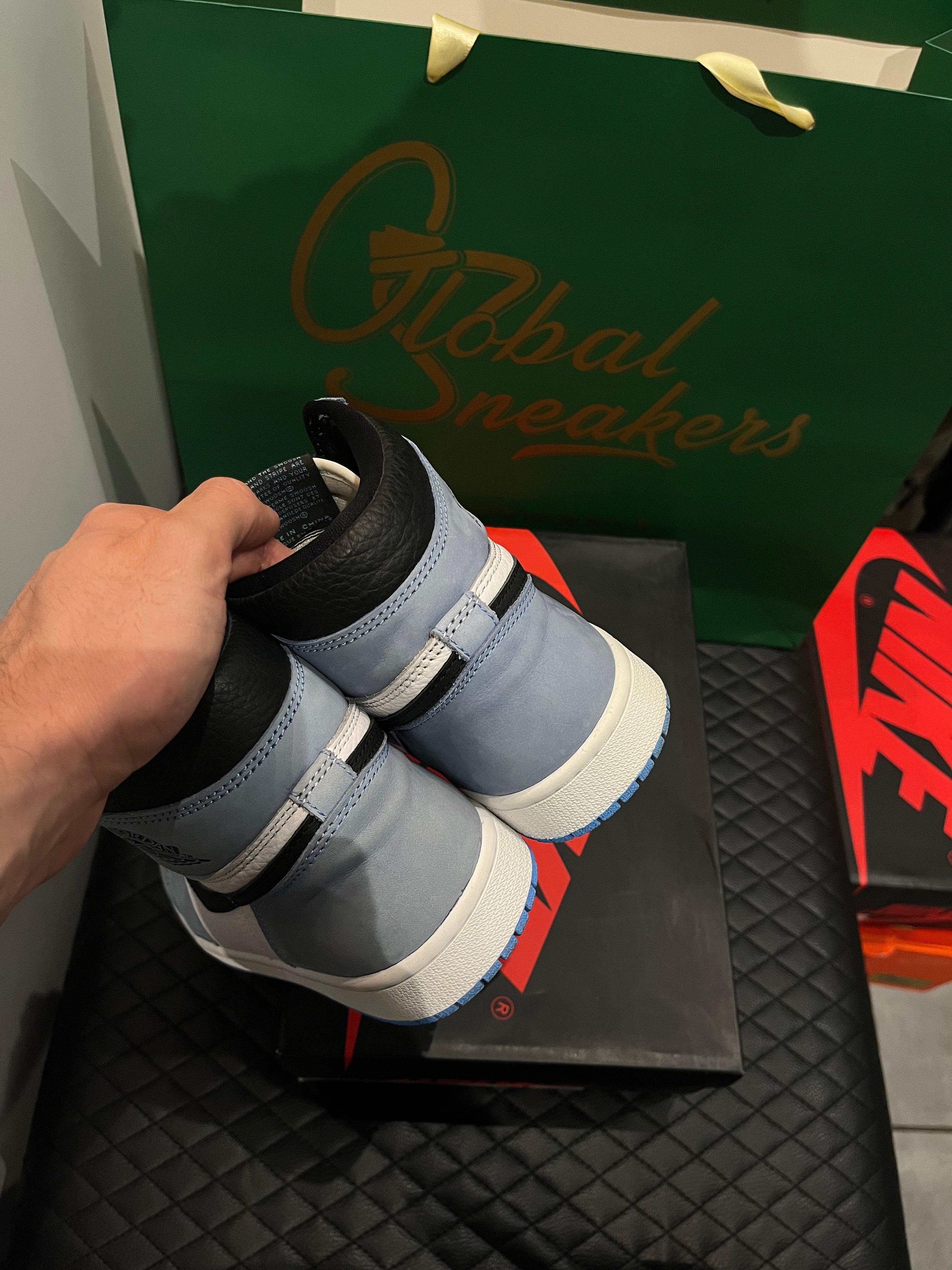 Jordan 1 Retro High OG University Blue d’occasion en état 8,5/10, cuir blanc, suede bleu ciel, silhouette haute classique, sneaker avec boîte.
