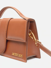 Jacquemus Le Grand Bambino Crossbody Flap Bag Light Brown, sac en cuir marron clair avec rabat, poignée supérieure et détails dorés.