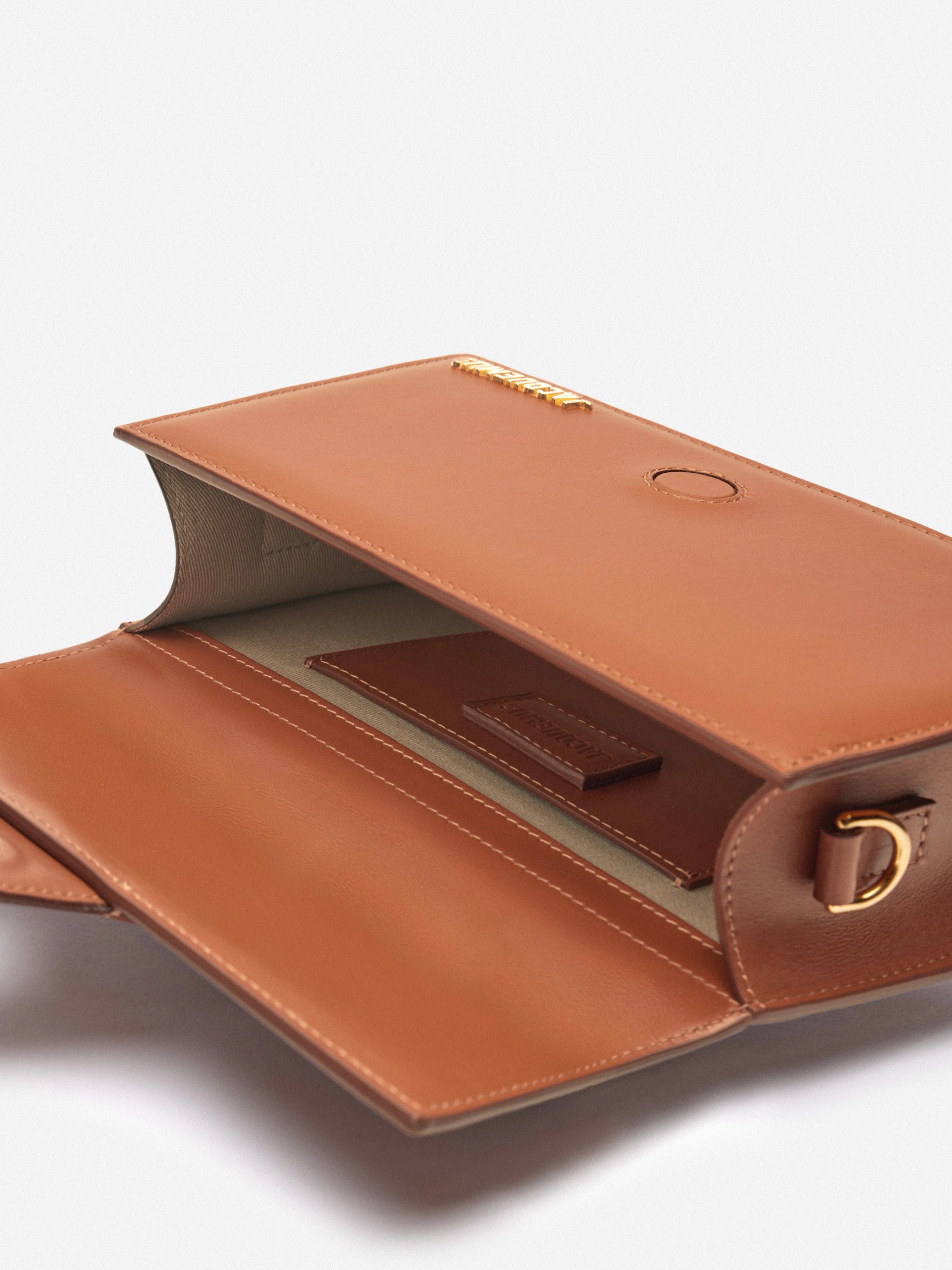Jacquemus Le Grand Bambino Crossbody Flap Bag Light Brown, sac en cuir marron clair avec rabat, poignée supérieure et détails dorés.