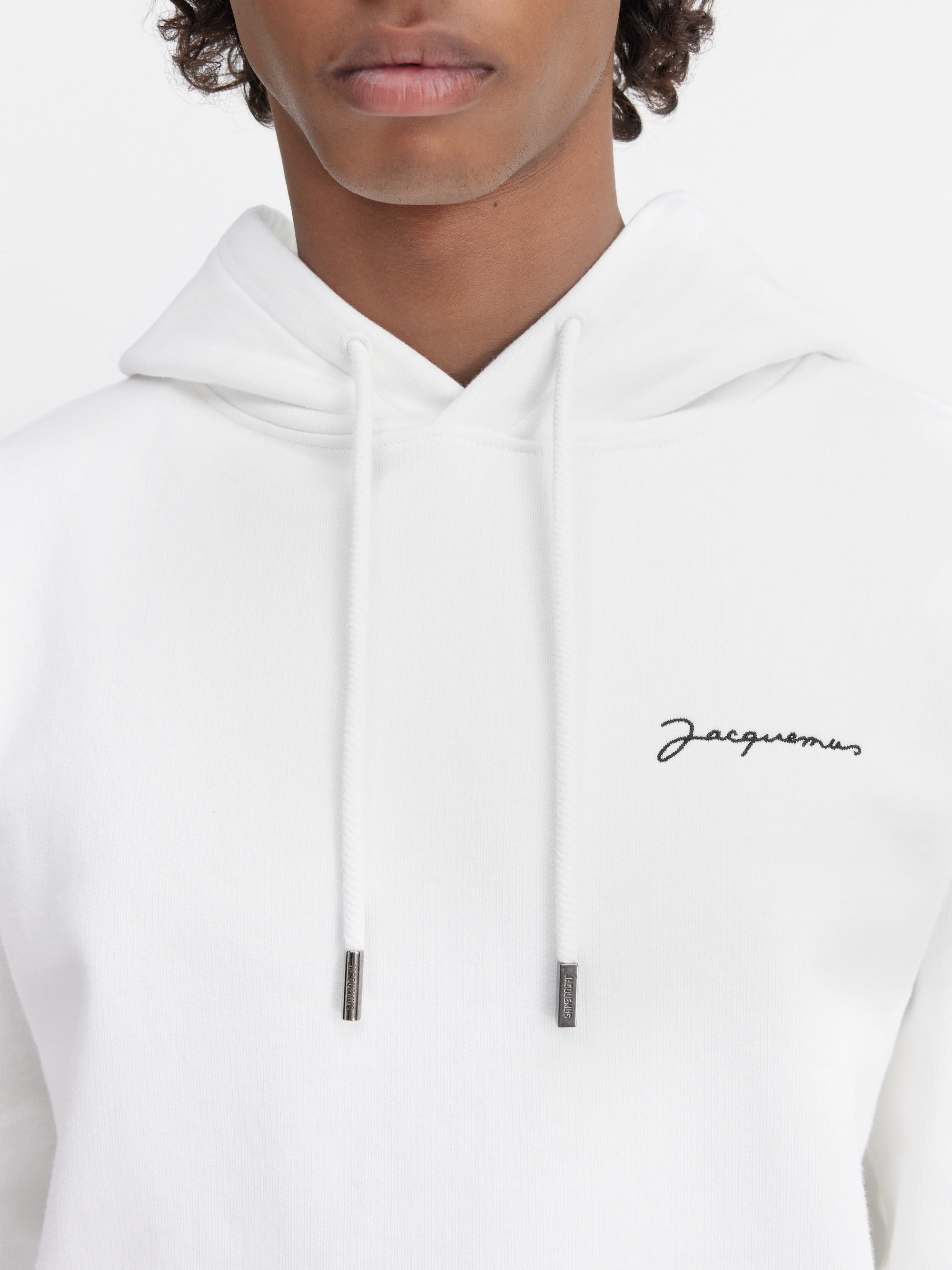 Jacquemus Le Sweatshirt Brodé Embroidered Logo Regular Fit Hoodie White/Black, hoodie Jacquemus blanc à coupe Regular Fit avec logo noir brodé et capuche.