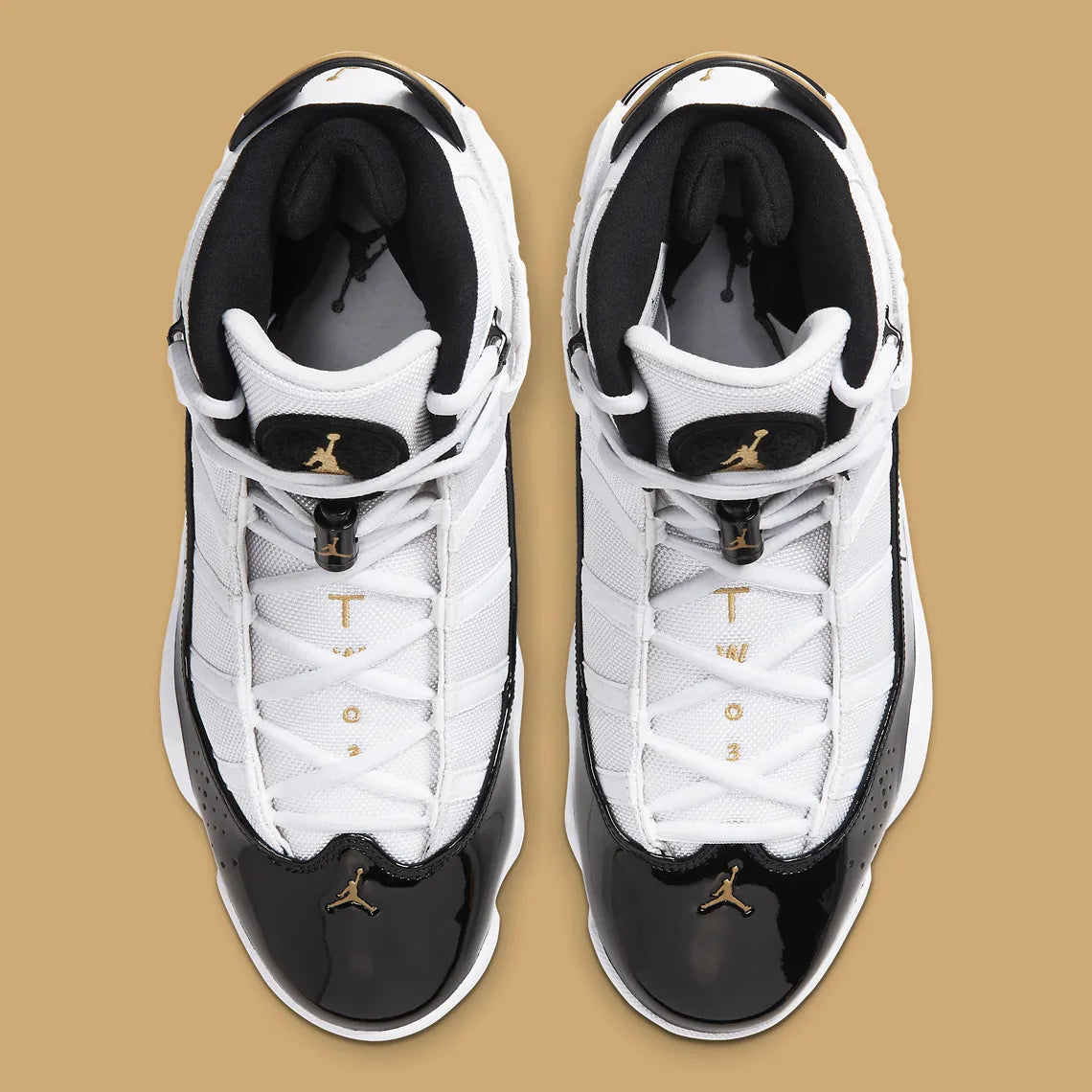 Air Jordan 6 Rings Defining Moments en blanc et noir avec empiècements en cuir verni, détails Metallic Gold et semelle translucide.