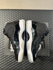 Jordan 11 Retro Space Jam 2016 d’occasion, cuir verni noir, mesh balistique, semelle translucide, sneaker en bon état général.