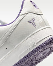 Sneaker Nike Air Force 1 Low Kobe Bryant Forever blanche Summit White en cuir premium avec détails Daybreak et semelle Air iconique.