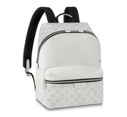 Louis Vuitton Discovery Backpack Optic White en toile Monogram et cuir Taïga blanc avec finitions palladium, poche avant zippée et bretelles réglables.