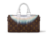 Louis Vuitton Keepall Bandoulière 25 Metallic en cuir Monogram à finition métallisée avec poignées roulées, bandoulière réglable et amovible, fermeture zippée à double curseur et finitions métalliques.