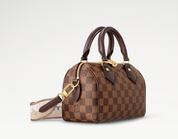 Louis Vuitton Speedy Bandoulière 20, sac Louis Vuitton compact avec doubles poignées Toron, fermeture zippée et bandoulière ajustable.