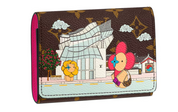Image du Louis Vuitton Victorine Wallet Vivienne Holiday en toile Monogram avec illustration Vivienne et doublure cuir fuchsia, présenté fermé avec bouton-pression.