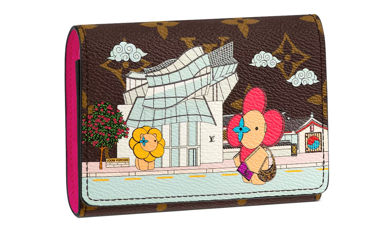 Image du Louis Vuitton Victorine Wallet Vivienne Holiday en toile Monogram avec illustration Vivienne et doublure cuir fuchsia, présenté fermé avec bouton-pression.