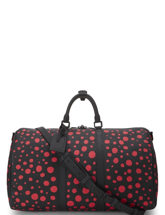 Red avec motifs signatures rouges de Yayoi Kusama sur fond noir, poignées roulées, bandoulière amovible, fermeture zippée et finitions métalliques.