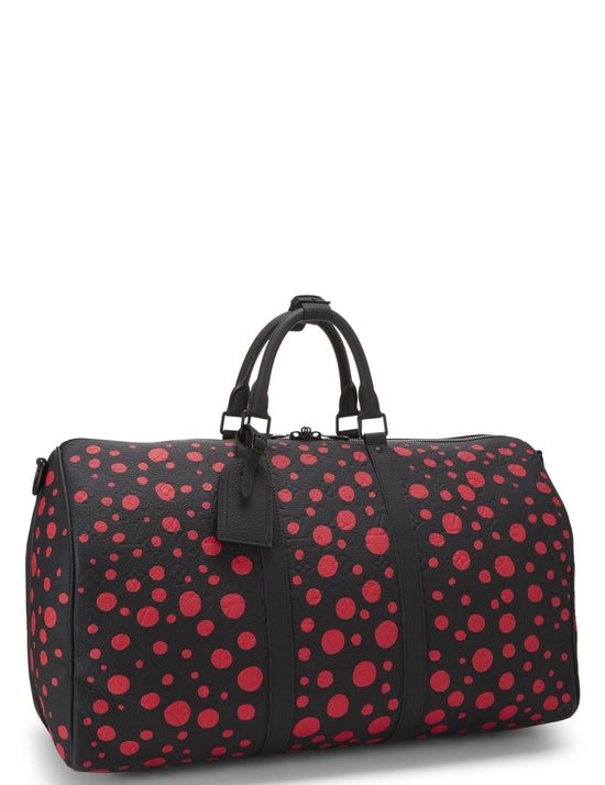 Red avec motifs signatures rouges de Yayoi Kusama sur fond noir, poignées roulées, bandoulière amovible, fermeture zippée et finitions métalliques.