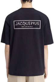 TEE SHIRT JACQUEMUS BLEU MARINE AVEC UN LOGO "J" EN FORME DE POISSON SUR LE COEUR ET UN GROS CADRE INSCRIT JACQUEMUS AU DOS DU TEE-SHIRT