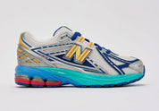 Sneaker New Balance 1906R en mesh blanc nacré, suède gris premium, détails argent métallisé, accents bleu et violet, amorti ABZORB et N-ergy, édition DLTR Moon Sign