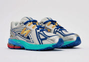 Sneaker New Balance 1906R en mesh blanc nacré, suède gris premium, détails argent métallisé, accents bleu et violet, amorti ABZORB et N-ergy, édition DLTR Moon Sign