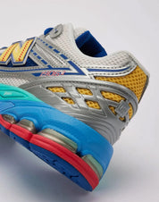 Sneaker New Balance 1906R en mesh blanc nacré, suède gris premium, détails argent métallisé, accents bleu et violet, amorti ABZORB et N-ergy, édition DLTR Moon Sign