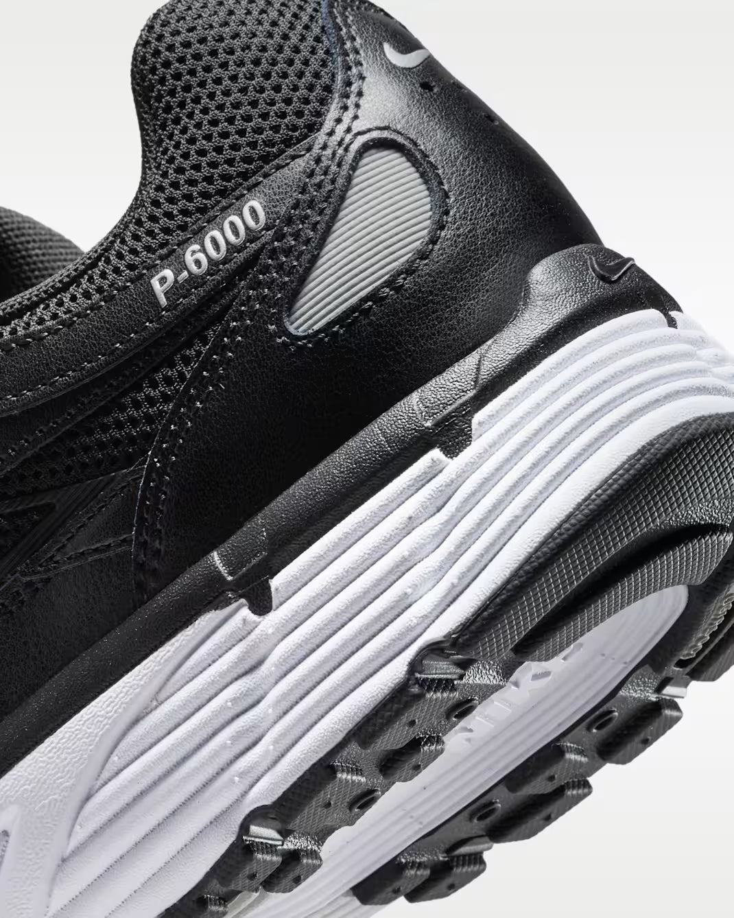 Vue zoomée sur les détails arrières de la Nike P-6000 Black White Metallic Silver noire, blanche et argentée avec mesh respirant, renforts superposés et détails Metallic Silver 