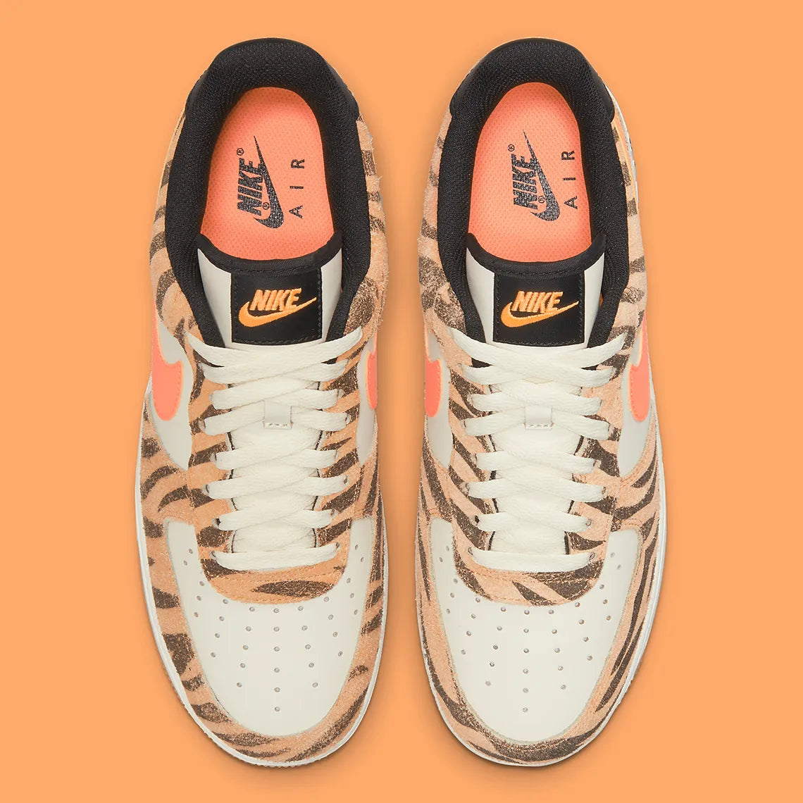 Nike Air Force 1 Low Daktari, sneaker en cuir Coconut Milk avec empiècements en suède zébré orange, Swoosh orange et semelle gomme.