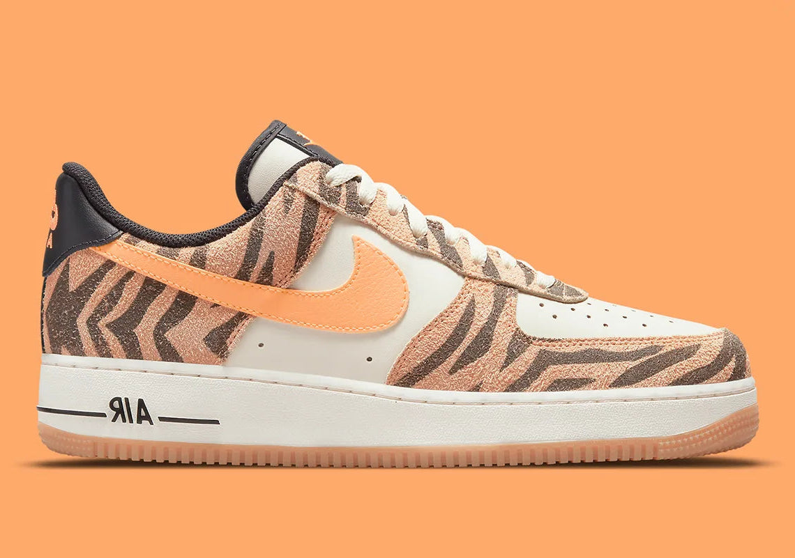 Nike Air Force 1 Low Daktari, sneaker en cuir Coconut Milk avec empiècements en suède zébré orange, Swoosh orange et semelle gomme.