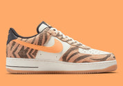Nike Air Force 1 Low Daktari, sneaker en cuir Coconut Milk avec empiècements en suède zébré orange, Swoosh orange et semelle gomme.